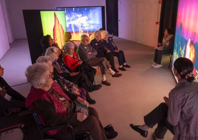 Visita museale con anziani davanti a installazioni luminose, attività di mediazione culturale